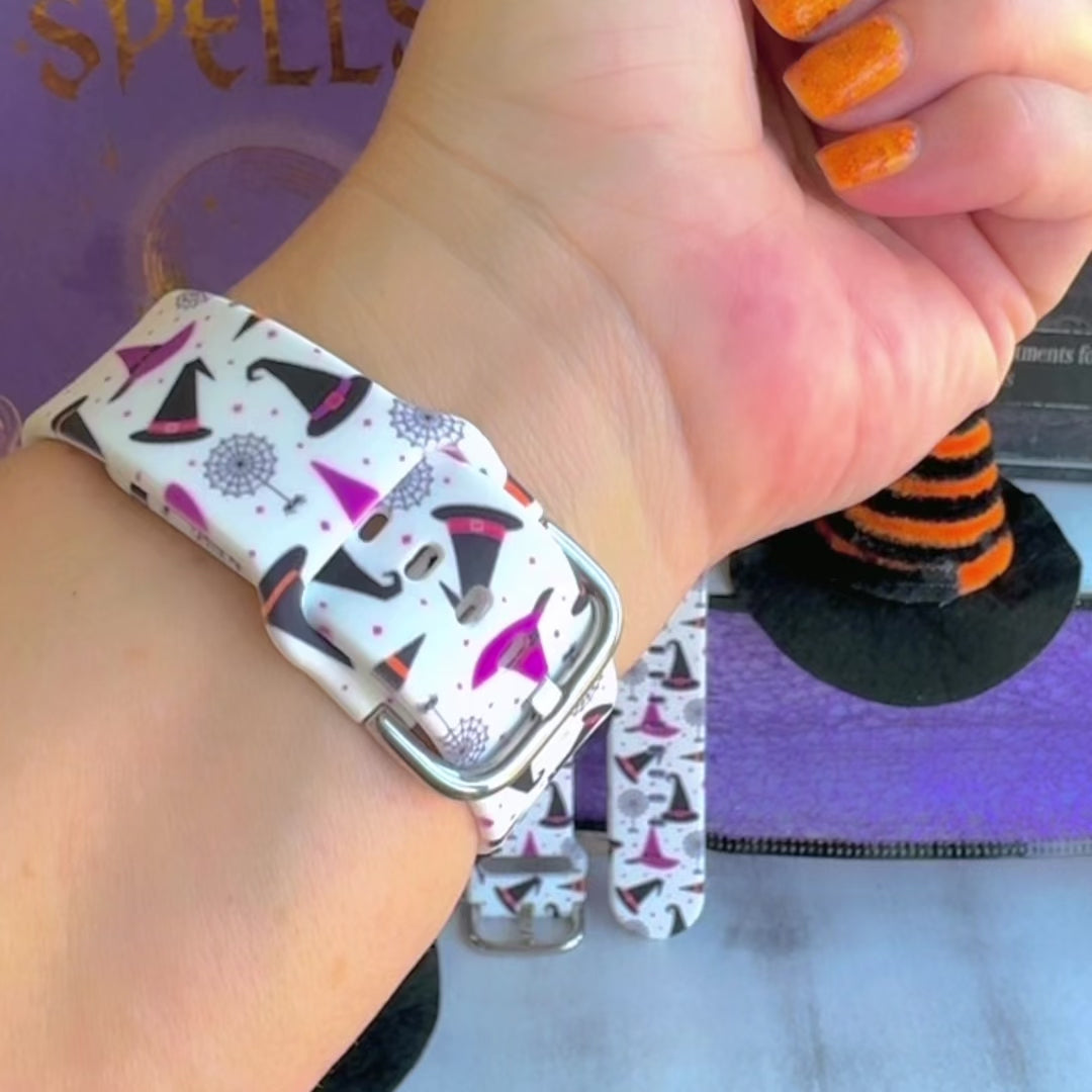 Video of the Witch Please Fitbit Versa 3/4 and Sense band showing the cream strap with purple witch hats and Witch Please script.