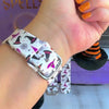 Video of the Witch Please Fitbit Versa 3/4 and Sense band showing the cream strap with purple witch hats and Witch Please script.