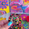 Bloom Bonita folk art floral MagSafe phone grip ring with vibrant pink red yellow and teal flowers on a black background compatible with iPhone and Samsung
