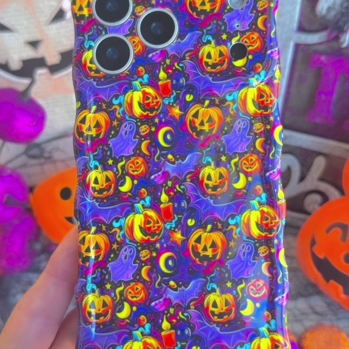 Video of the Jack-O-Lantern Jive Wavy Luxe MagSafe iPhone case turning in hand to show the violet neon pumpkin print and the sculpted wavy edge.