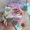 Video: Champagne Snowfall scrunchie wrist strap worn on the wrist with the matching iPhone case hanging from the clasp