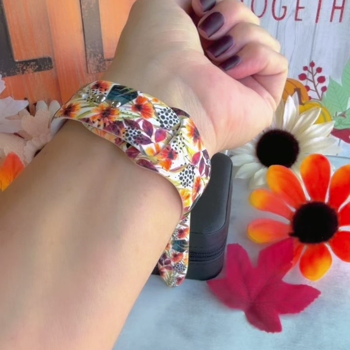 Video of the Sienna Petals silicone Apple Watch band worn on the wrist and shown in both sizes, cream with burnt orange watercolor flowers and teal leaves.